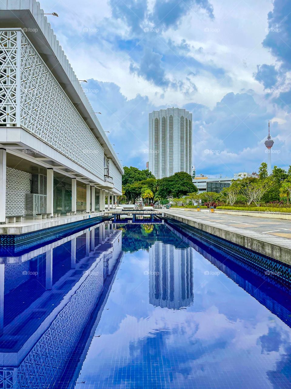 Mosque architecture view from outside with blue pond on the side