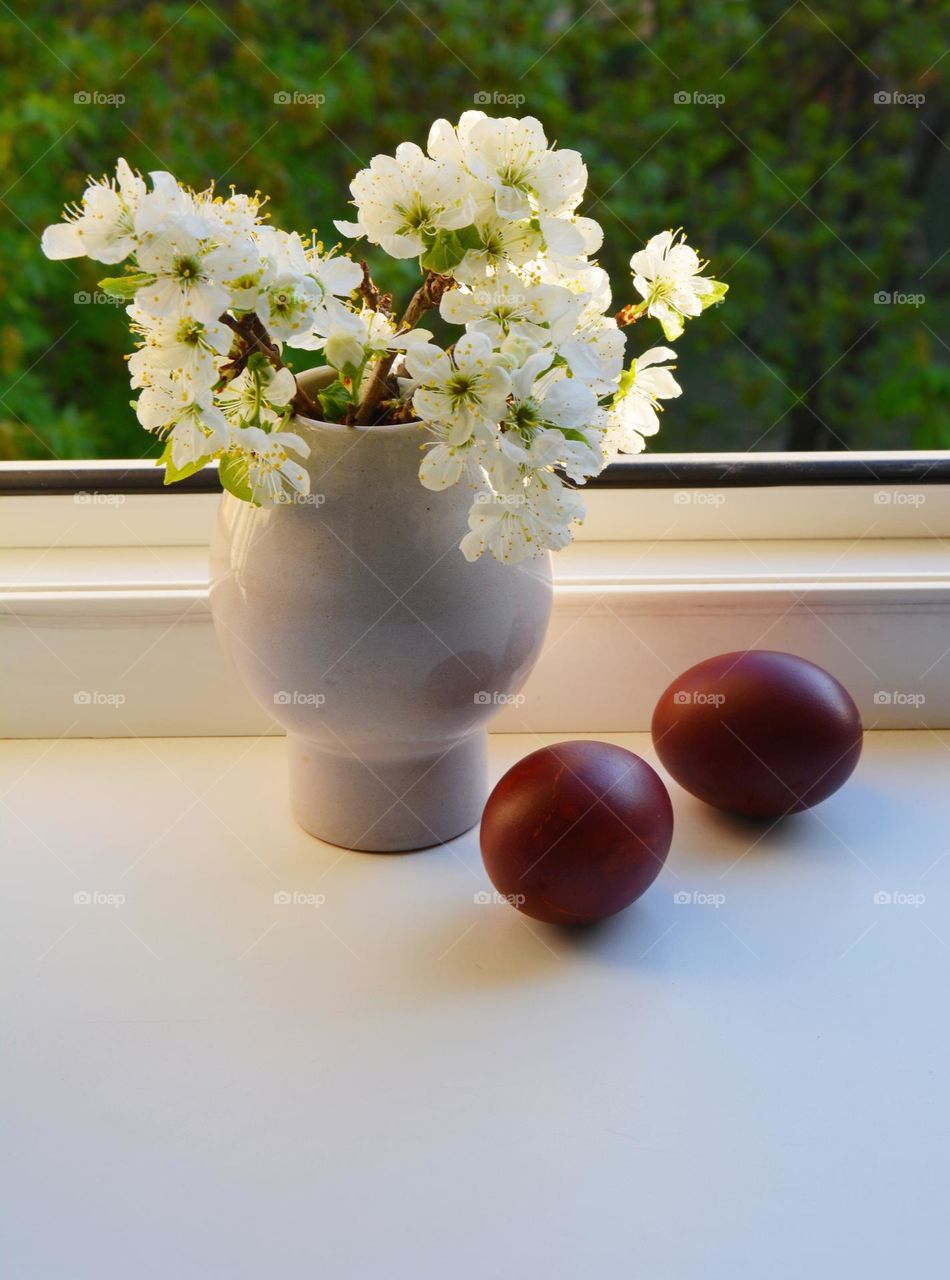 spring flowers in vase and red eggs Easter holiday