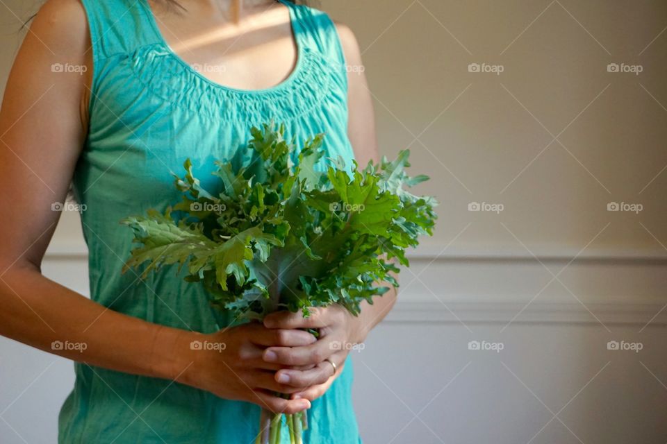 Woman holding bouquet of kale