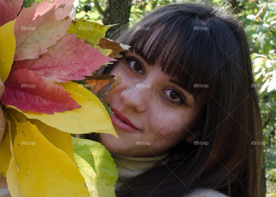 Portrait of Smiling Young Girl on Autumn Background