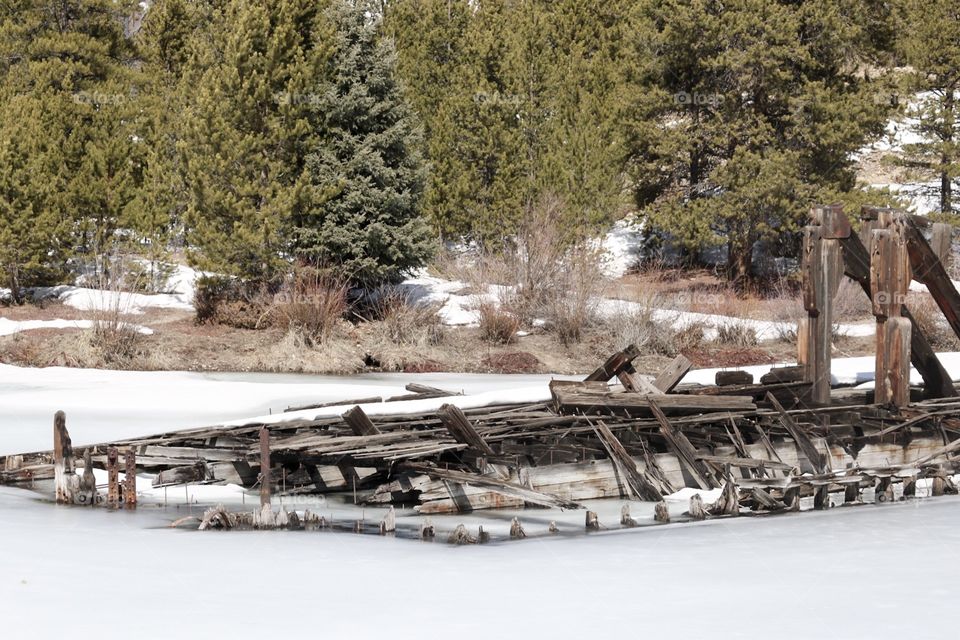 An abandoned gold mining dredge, frozen in a mountain lake in Colorado. 