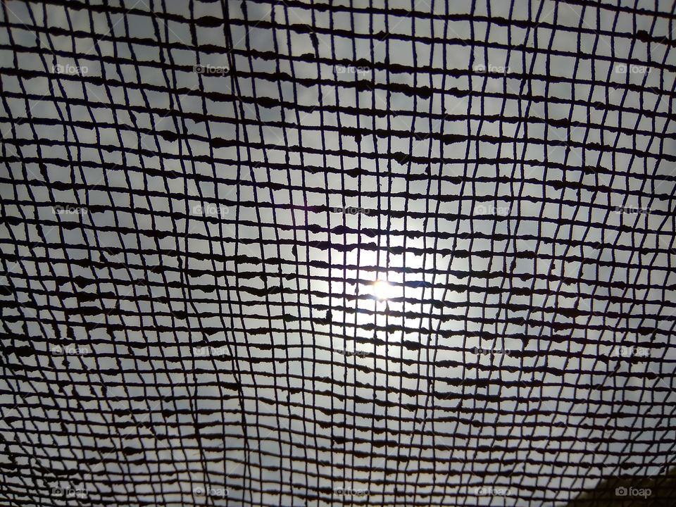 Beautiful sun through Metal net..