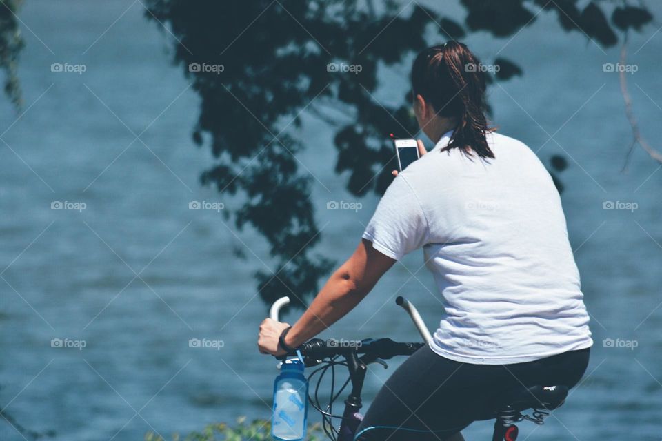 Woman on a bike checking her phone