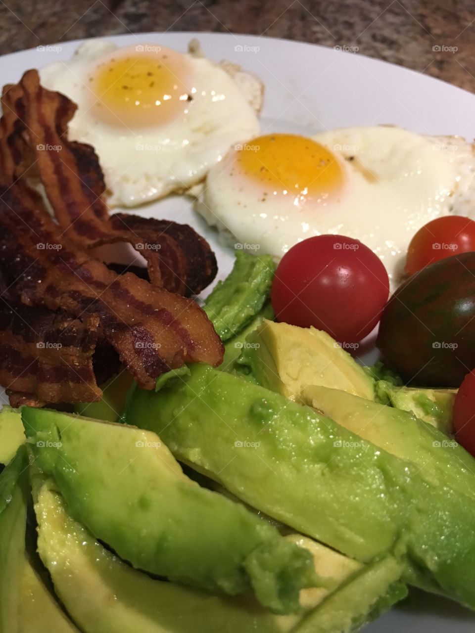 Eggs, bacon, avocado, and cherry tomatoes.