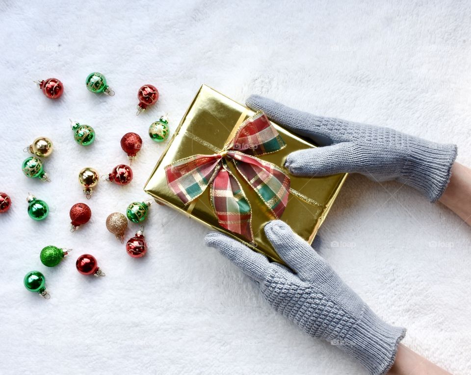 Christmas still life flat lay with woman holding a gift near ornaments