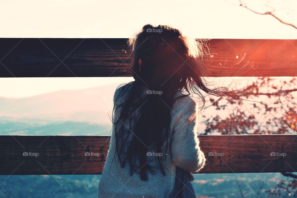 Rear view of woman standing near railing