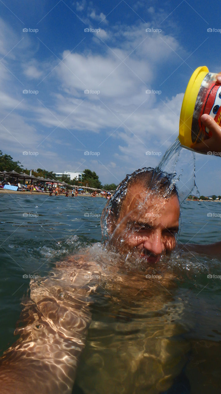 Man diving, man underwater smiling and relaxing in big blue sea with his camera