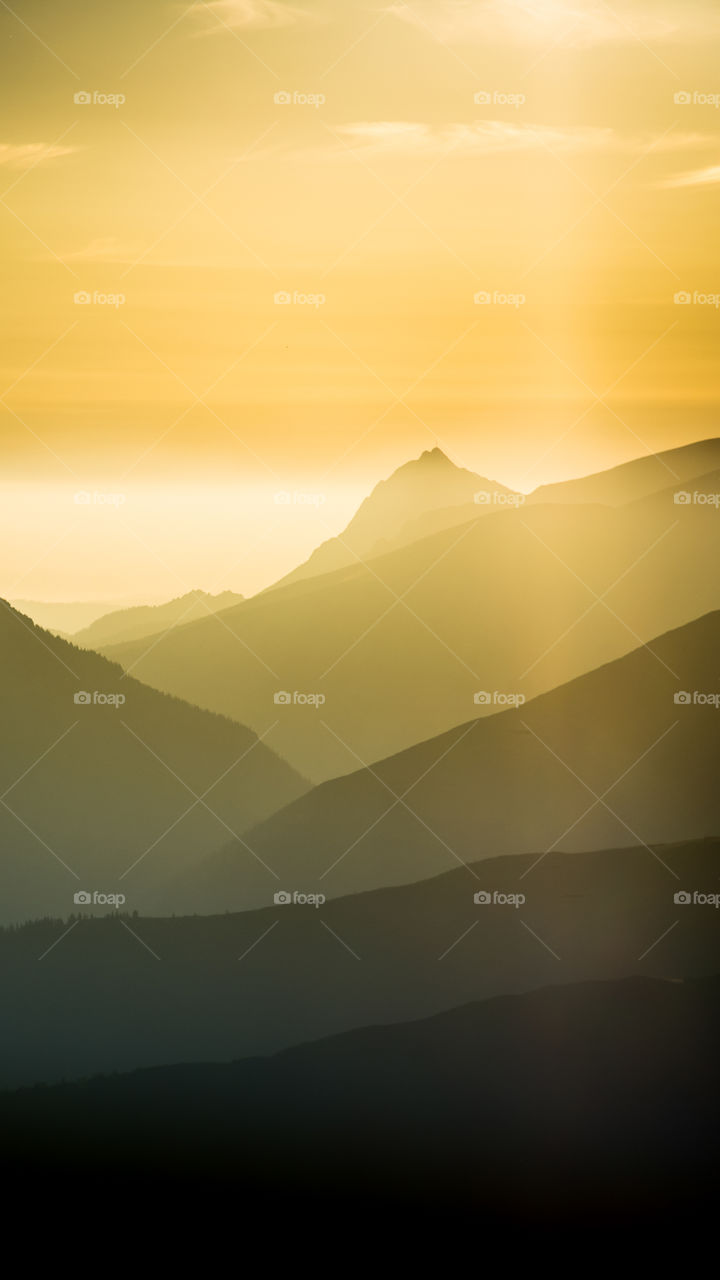 An inspiring mountain landscape. Tatry mountains in Slovakia. A beautiful wallpaper for smartphone screen. Warm summer haze, abstract gradient with perspective.