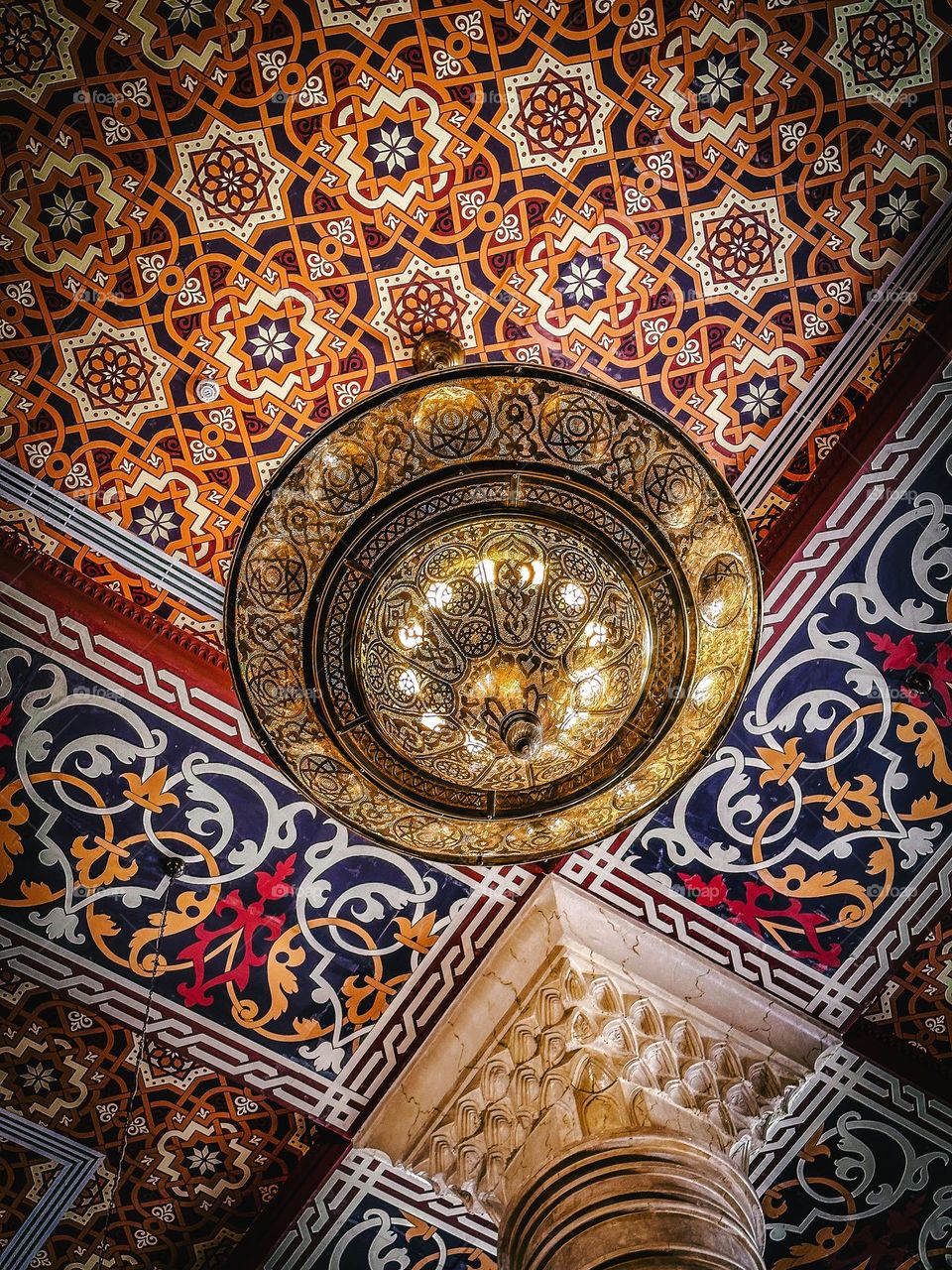 Ramadan is all about taking the time to reflect and worship. Muslims around the world spend more time at mosques during Ramadan than any other time of the year.  Islamic chandelier and wall-art on the ceiling of a Cairo mosque 