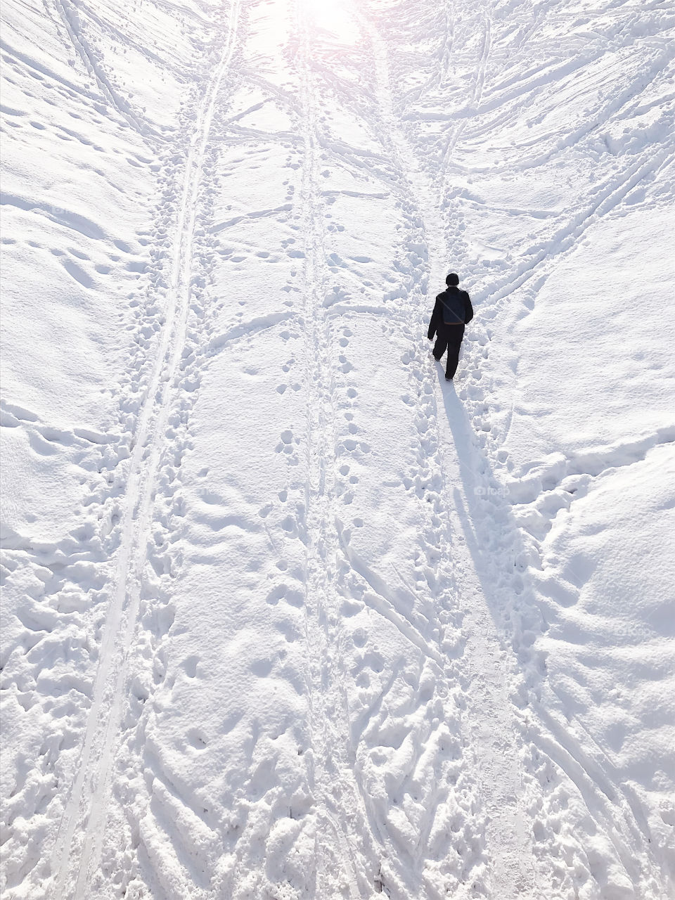 Walking by the footpath through the snowy field in winter, minimal concept 