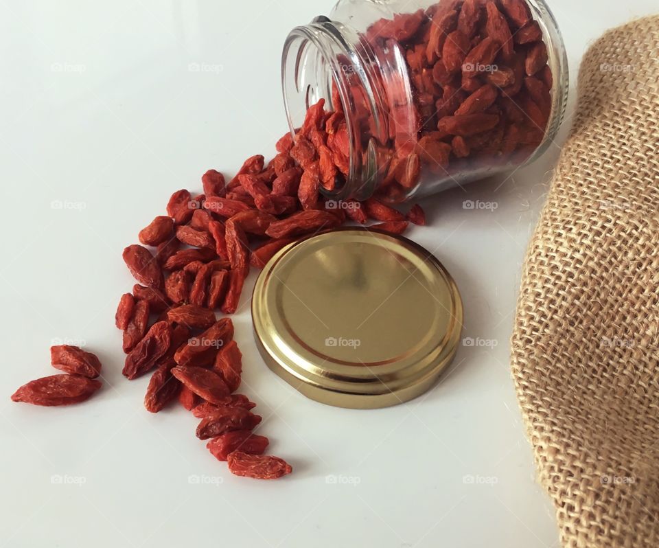 Goji berries in the jar. Because of the white background, red berries get all attention in the picture. 
