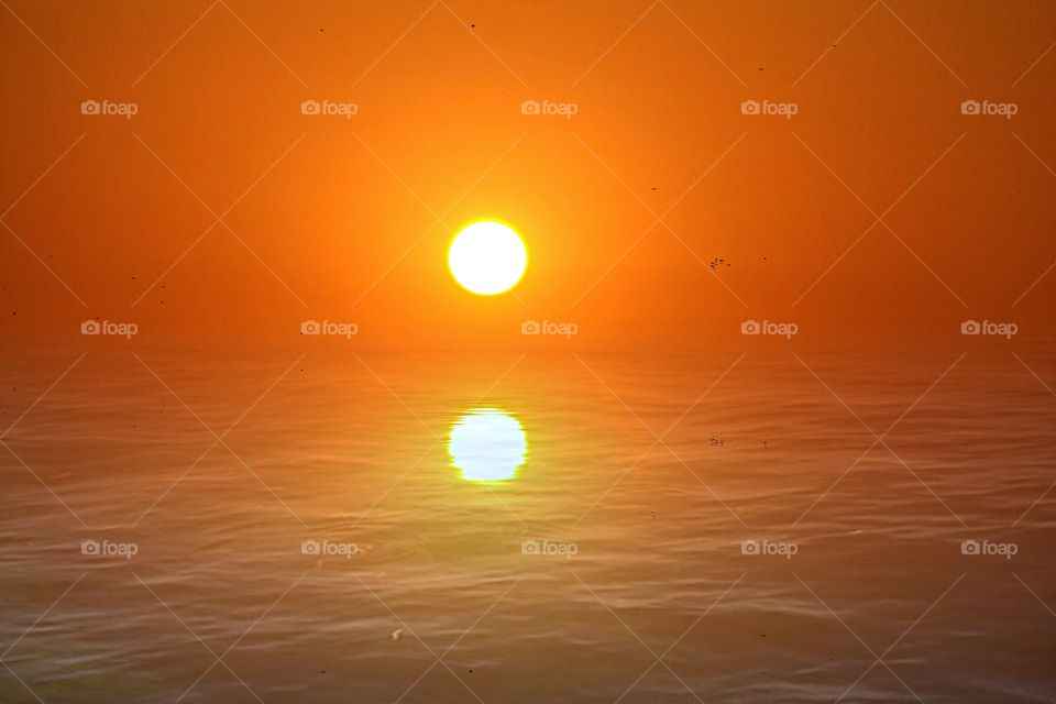 double Sunrise reflection with a reddish orange background. colorful, reflection sunrise