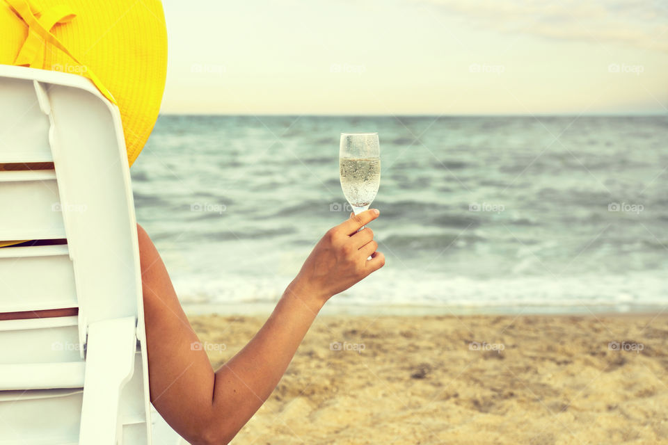 Woman drinking champagne on the coast