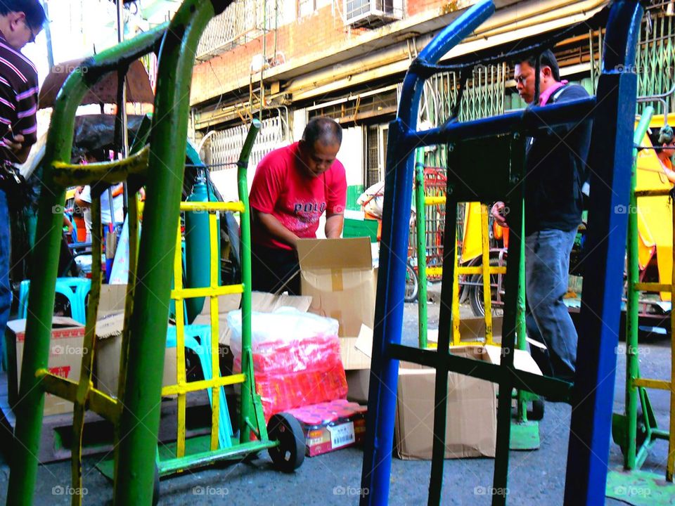 asian businessmen attend to their products and merchandise in quiapo, manila, philippines in asia