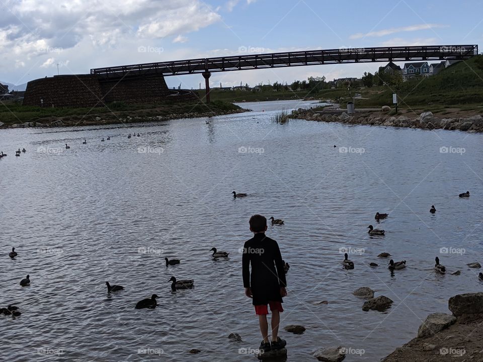 A Lake in Utah, a child standing on a rock on the lake. ©️ Copyright CM Photography