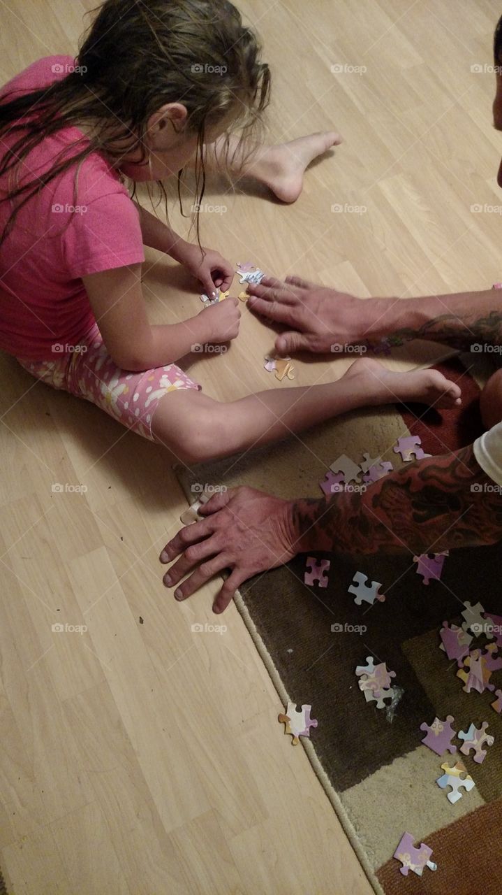 daddy and daughter have fun putting a puzzle together