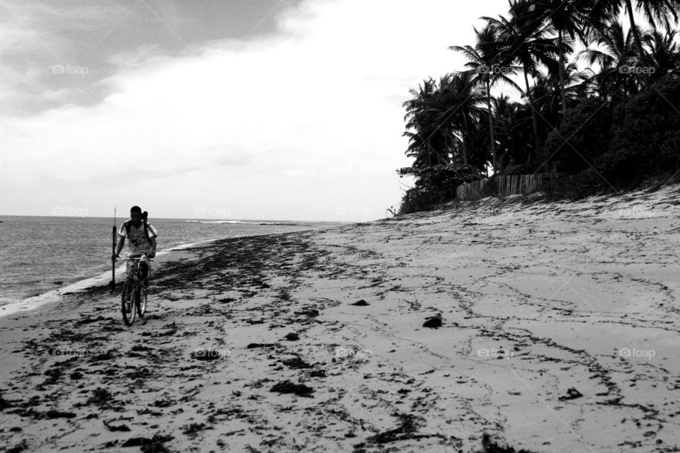 Man riding a bike at the beach in Bahia