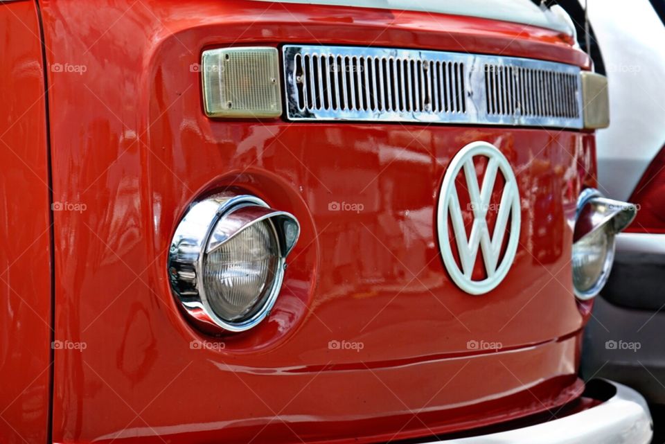 Ein roter VW-Bus mit weißen Akzenten als Teil-Fotografie.
