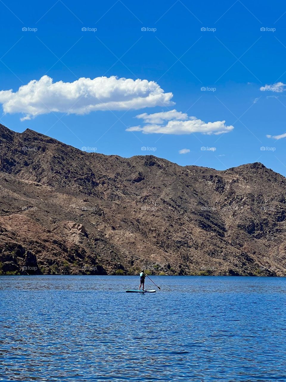 A person on a paddle board paddling around Willow Beach in Lake Mohave 