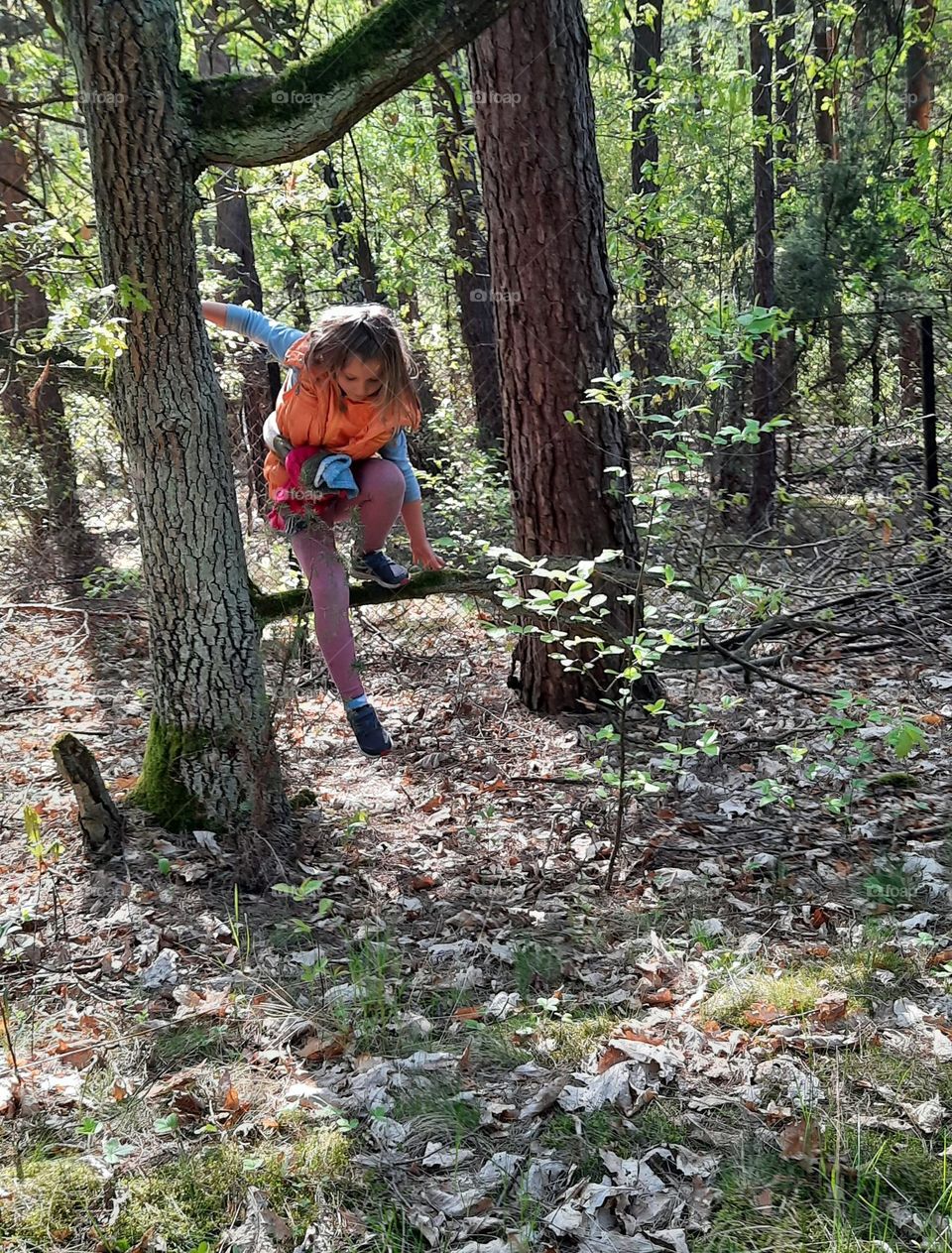 summer in the wood - girl jumping from a tree