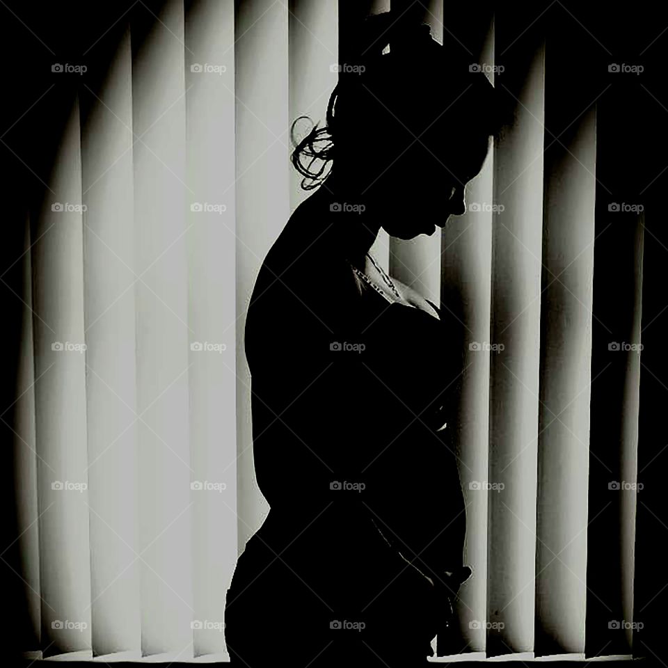 Black and white of a pregnant woman holding her stomach after an ultrasound.