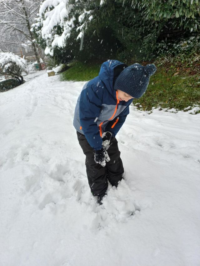 Criança  brincando  na neve.  As crianças,  gostam de brincar na neve, porque ela é mágica,  e encantadora