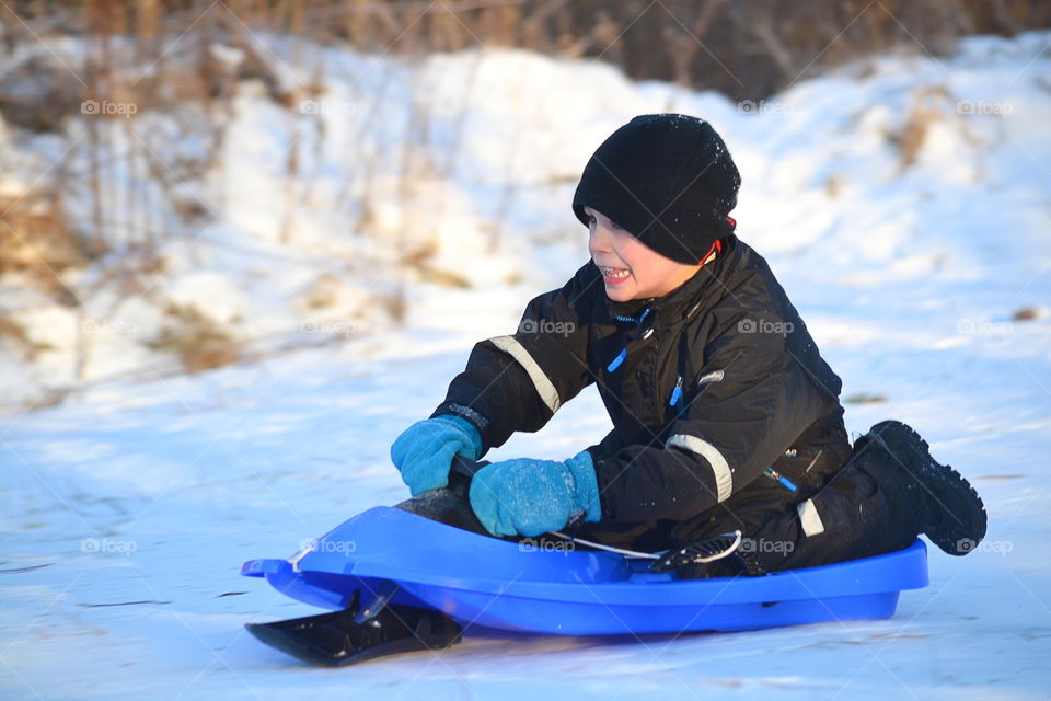 Boy playing on snowboard in winter