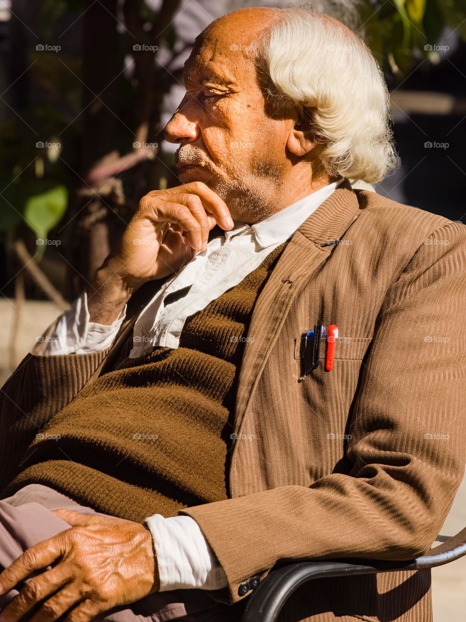 An old man sleeping with the blanket of bright sunlight in winter season