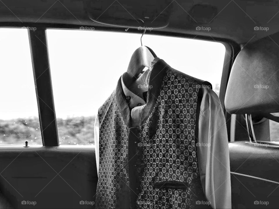 A men's suit hangs on a hanger in the car to change at work