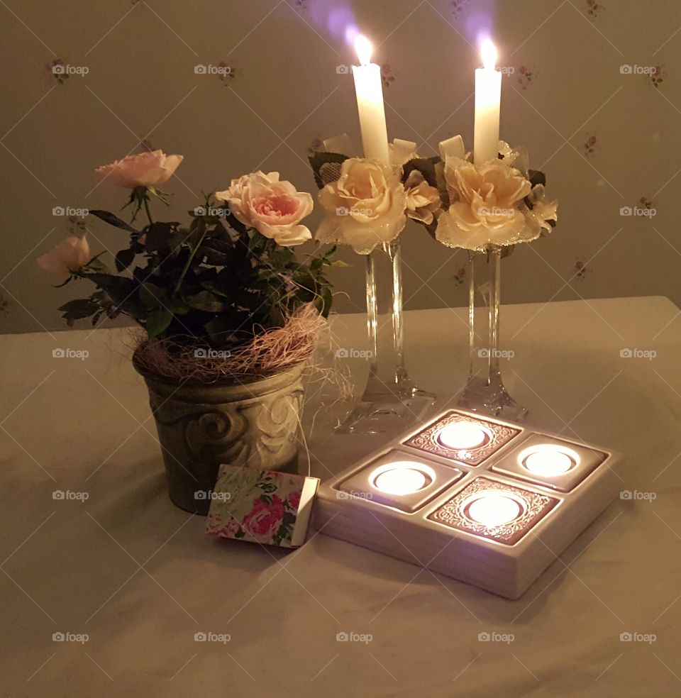 Lit candles and flower vase
