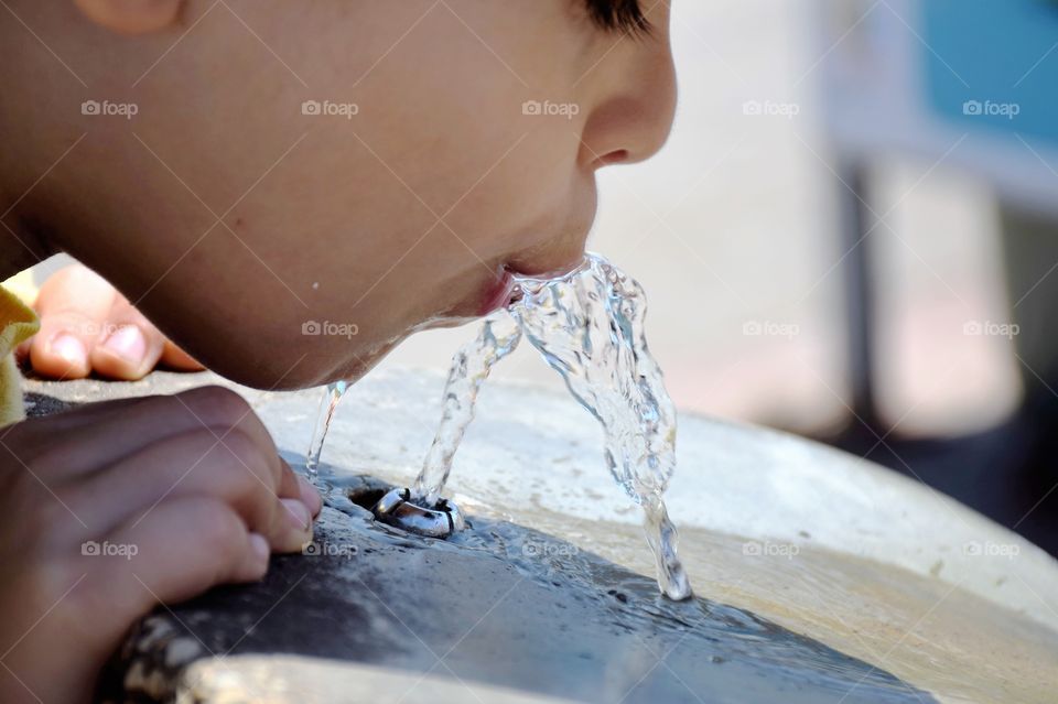 Child drinking water from fountain