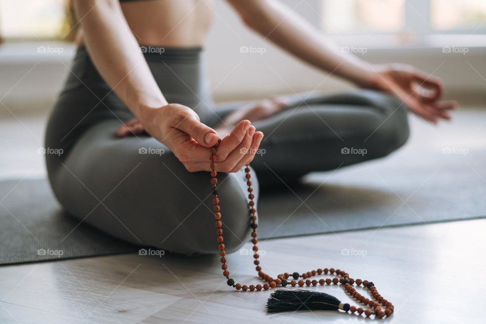 Young fit woman practice yoga doing asana lotus position in light yoga studio 