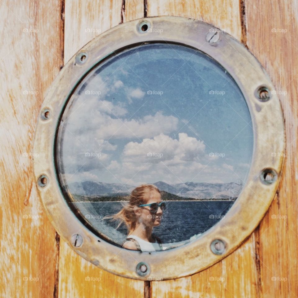 Girl reflected in ferry porthole