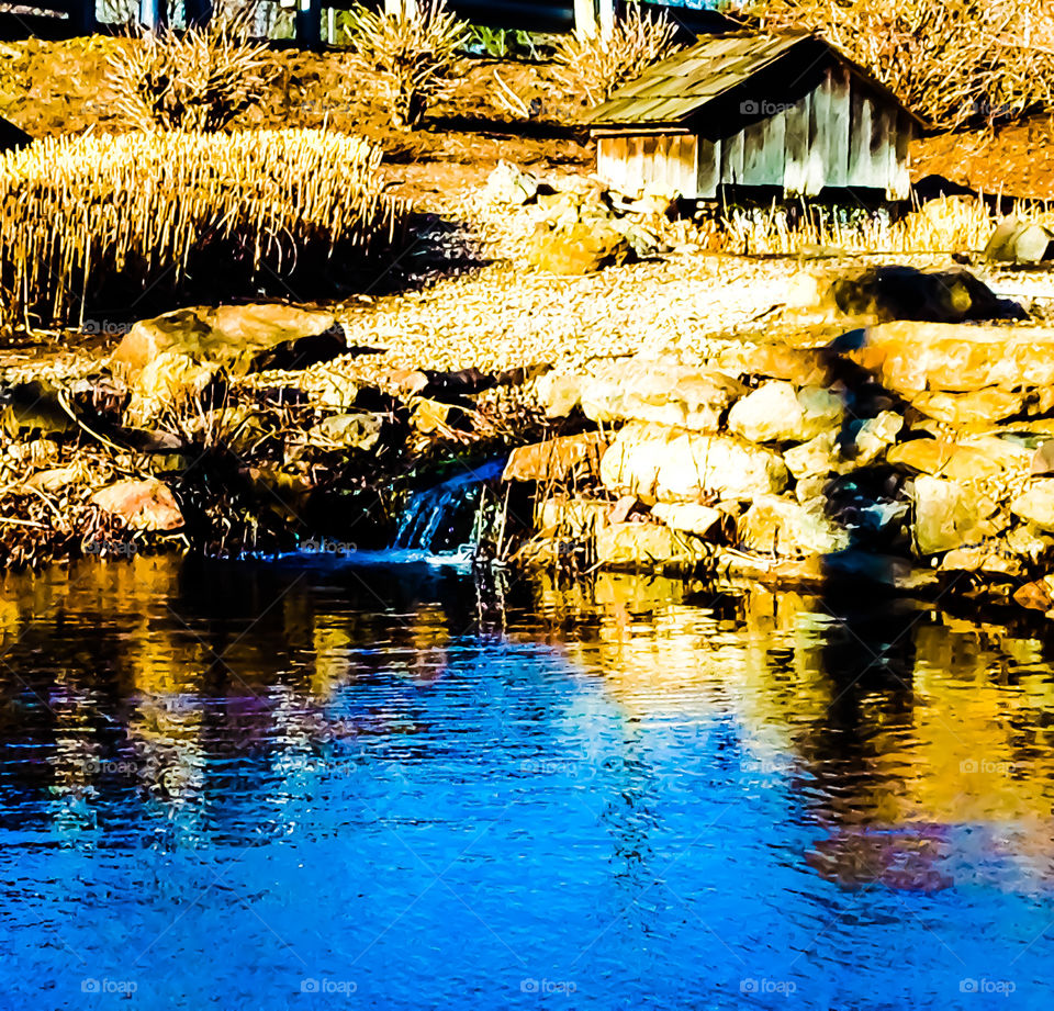 Barn by a lake with a mini waterfall 