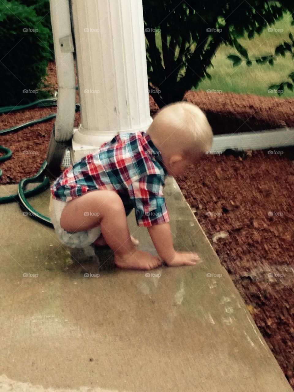 Playing in the water. Baby boy playing with the hose