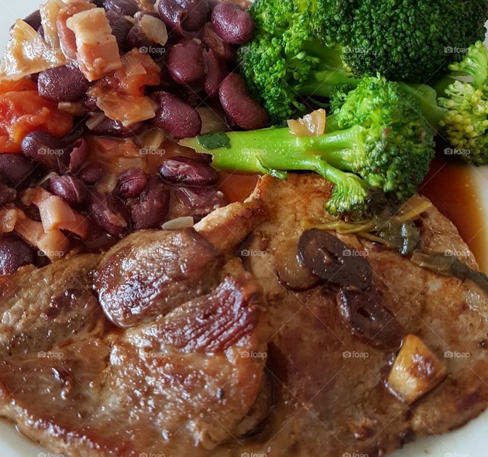 Steak with garlic sauce, beans and bacon, green vegetables 