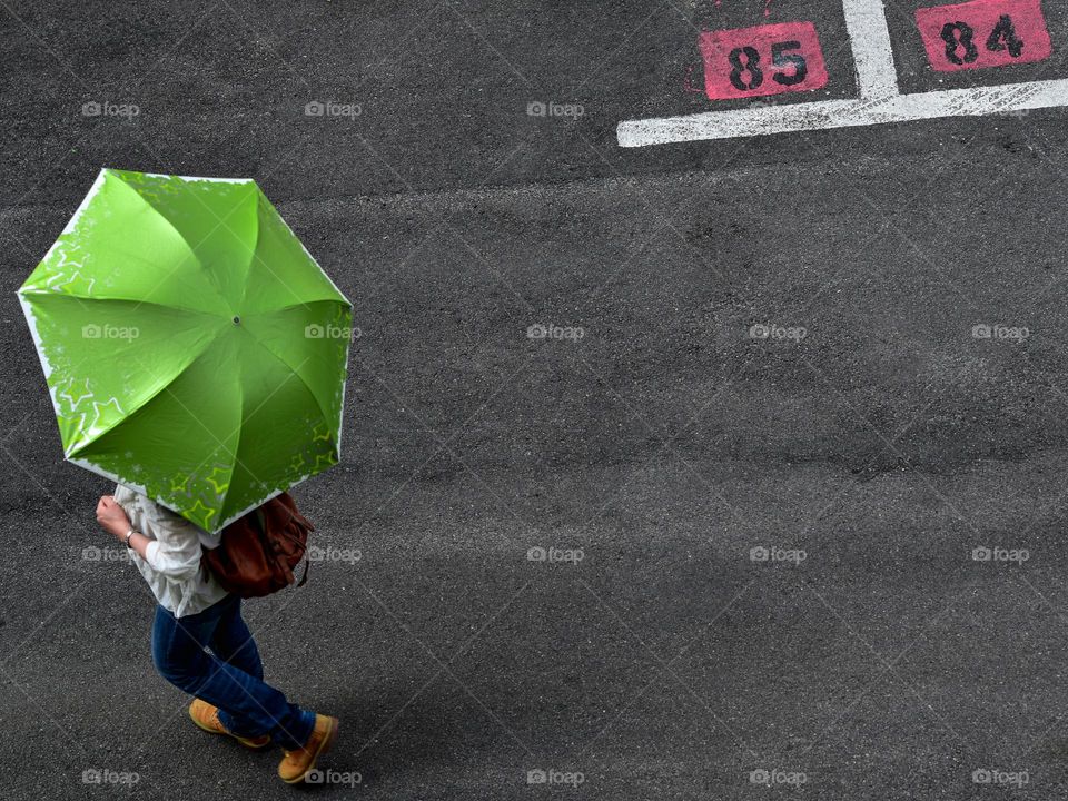 A lady with a green umbrella viewed from above