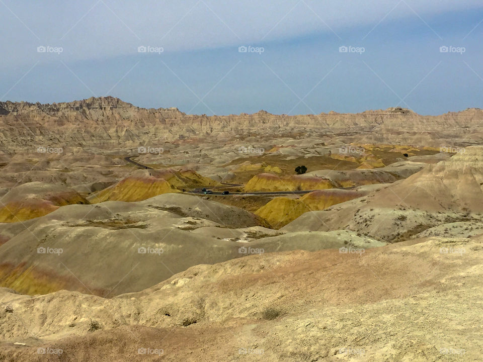 Landscape shot of an open valley in the Badlands National Park in South Dakota. The bright yellow pigment in some of the hills is clearly visible.