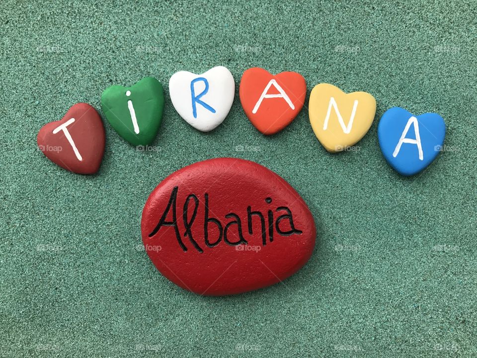 Tirana, Albania, souvenir with multicolored stone hearts over green sand 
