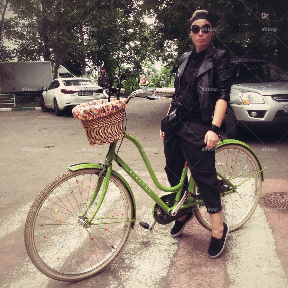 Woman in black with sunglasses with green electra amsterdam green city bicycle