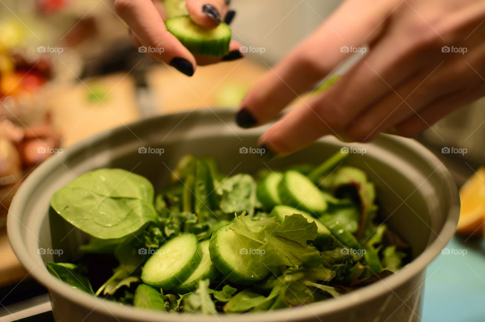 Making healthy salad with fresh greens 