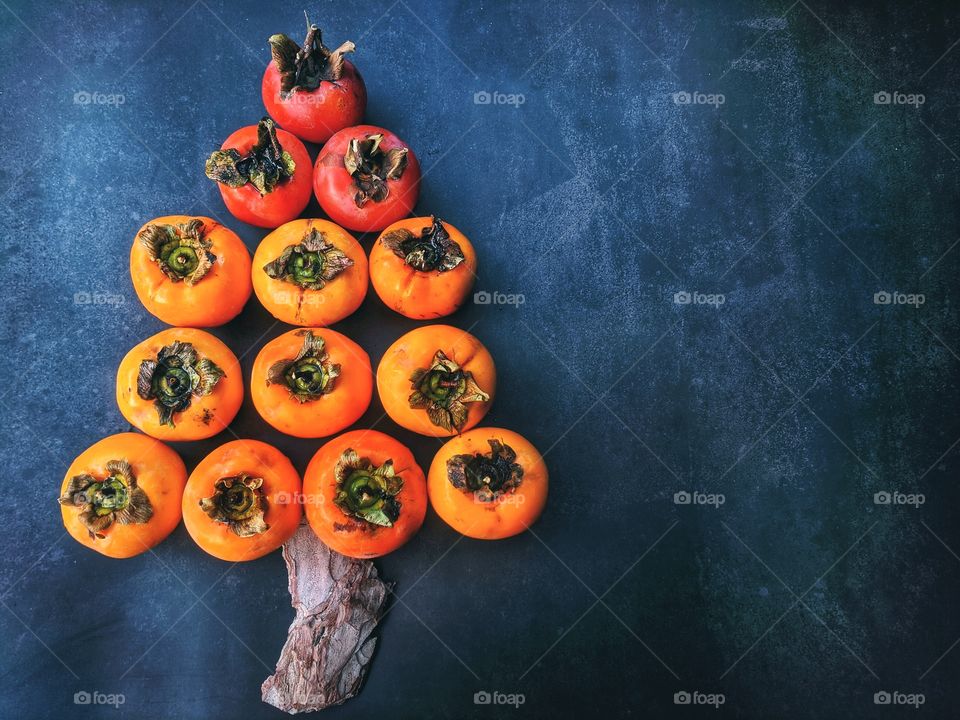 Background from natural and fresh persimmons collected from our own garden. Christmas tree of the persimmons. top view. close-up pine tree