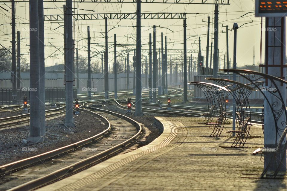 railroad tracks and many railroad poles with electricity.