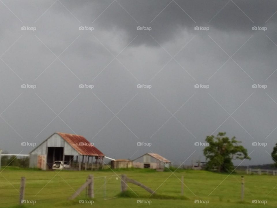 storm clouds behind farm sheds