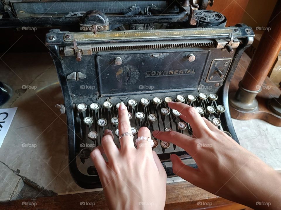 A girl typing on an antique typewriter.