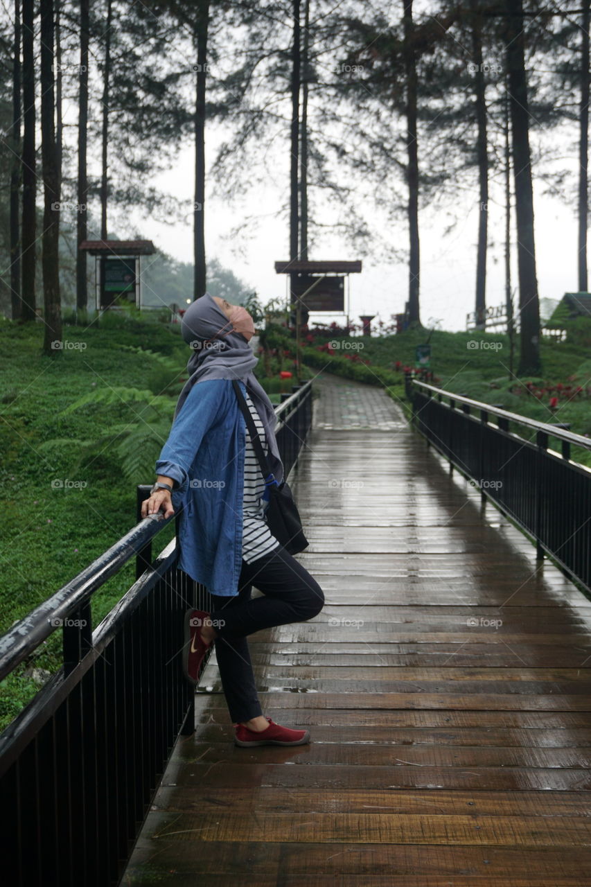 woman walk through bridge in rainy days