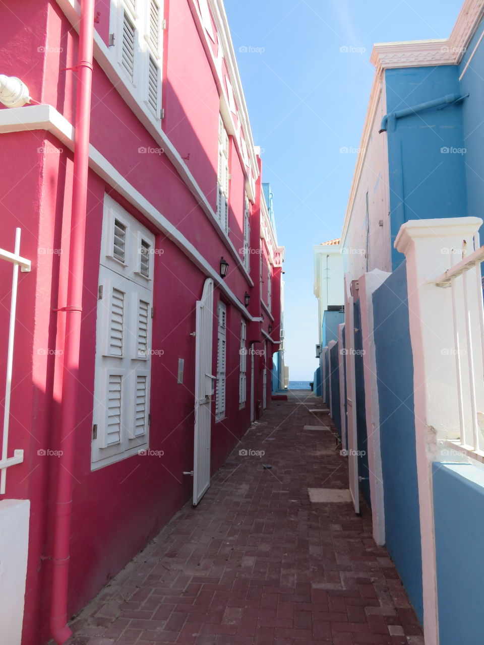 Summer vibes - colorful buildings alongside an alley leading to the Carribean Sea