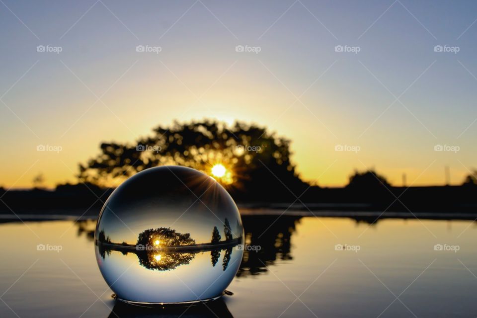 Glass ball on water at Sunset
