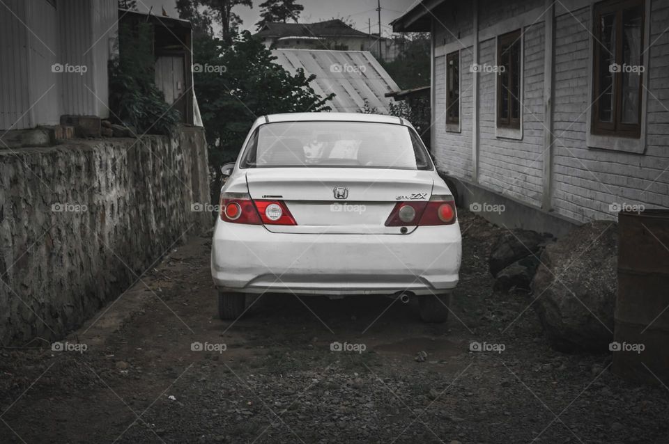 A white car in a narrow alley