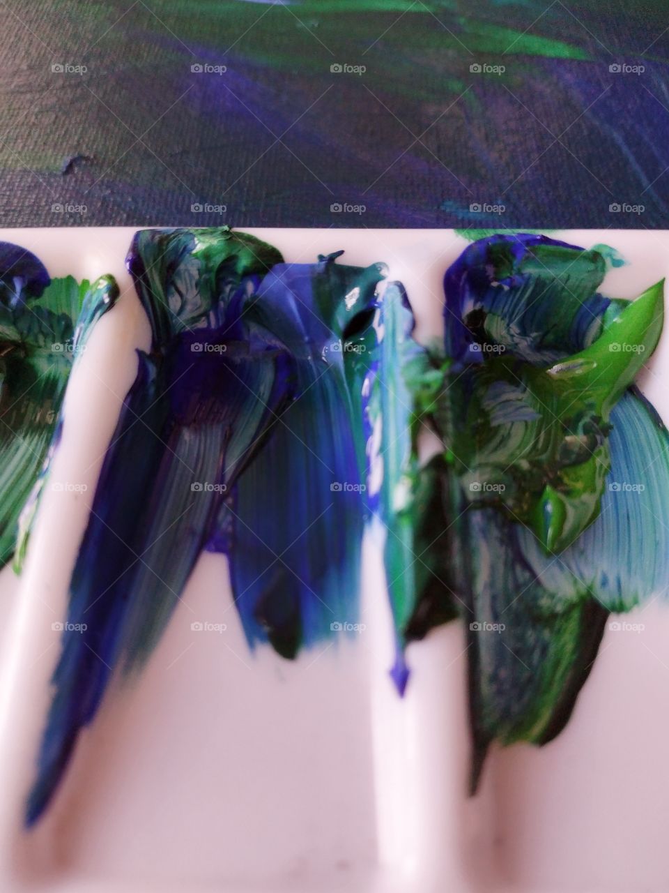 Unfiltered, beautiful, lovely close-up of a paint palette with blue and green paint
